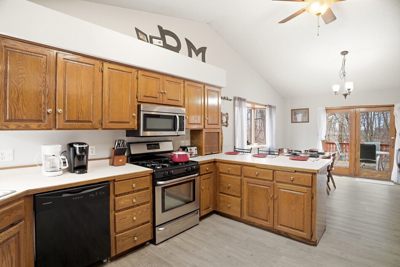 A kitchen with wooden cabinets, a microwave, a stove, and a dishwasher.