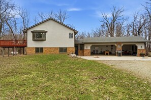 A two-story house with a covered garage, a fenced yard, and a wooden deck. - Private Lake Retreat with Fire Pit and Pool Table (Faribault)
