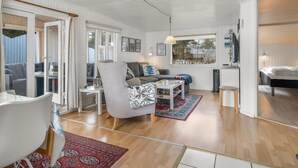 Ein kompakter Wohnbereich mit Essbereich, einer Couch, einem kleinen Tisch und einem Fenster mit Blick.