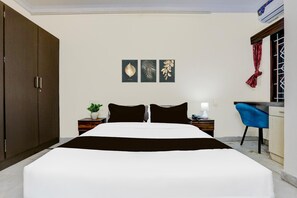 Un dormitorio con cama, escritorio, silla, armario y decoración en la pared.