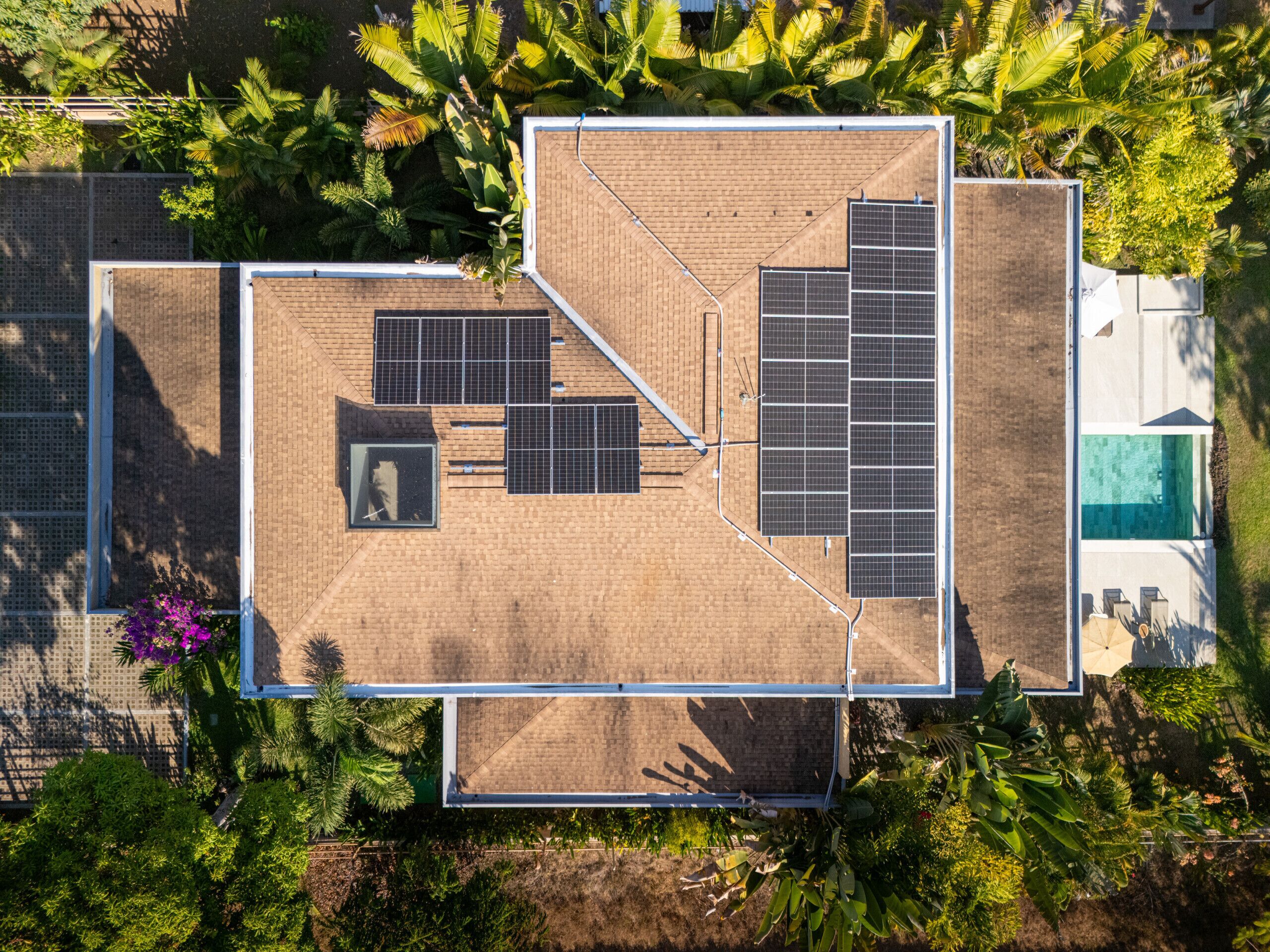 Eine Luftaufnahme eines Gebäudes mit Dachgarten, Solaranlagen und einem Schwimmbad.