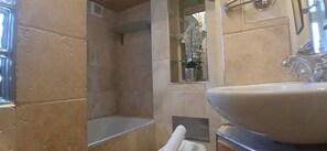 Une salle de bain avec un grand lavabo, un miroir et un espace douche.