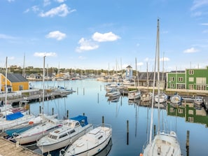A marina with boats docked, a lighthouse, and buildings along the waterfront. - "Björk" - 10m from the sea by Interhome (Ebeltoft)