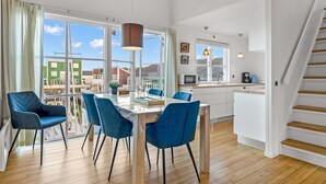 A modern kitchen with a dining area, large windows, and a staircase. - "Björk" - 10m from the sea by Interhome (Ebeltoft)