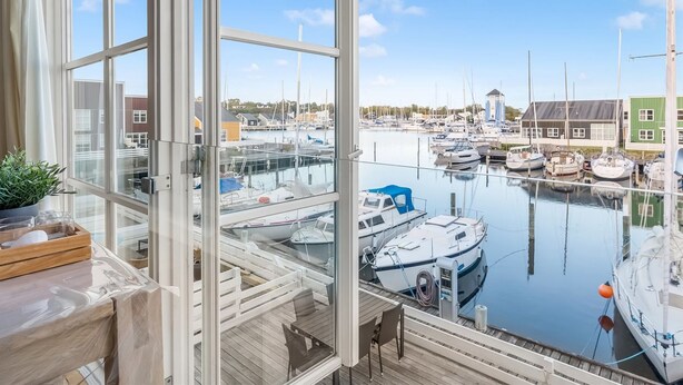 A view from a room with large windows overlooking a marina with boats docked. - "Björk" - 10m from the sea by Interhome (Ebeltoft)