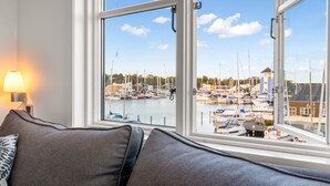 A room with a view of a marina, a sofa, and a lamp. - "Björk" - 10m from the sea by Interhome (Ebeltoft)