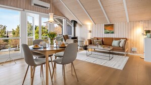 Ein modernes Interieur mit Essbereich, einer Couch und einer Küche.
