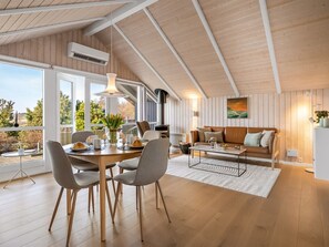 En modern inredning med ett matområde, en soffa och ett kök.