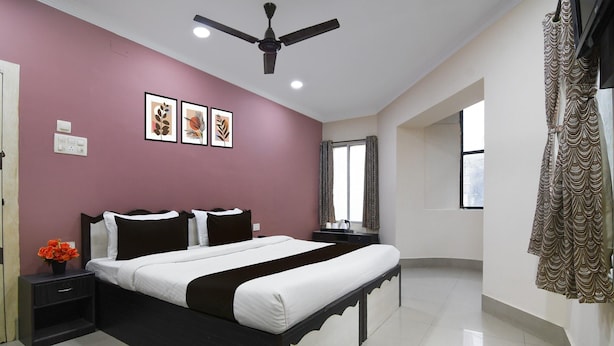 A bedroom with a bed, nightstands, a ceiling fan, and framed artwork on the wall. - Classic With Twin Bedrm Guest Home (Kolkata)