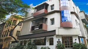 A multi-story building with a storefront labeled 'Collection.' - Classic With Twin Bedrm Guest Home (Kolkata)