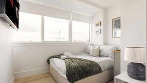 A bedroom with a bed, a window, a bedside table, and a lamp. - 1 Min Walk to Wembley Stadium Sleeps 10 Gym (London)