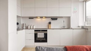 A modern kitchen with white cabinetry, a built-in oven, and a window with a view. - 1 Min Walk to Wembley Stadium Sleeps 10 Gym (London)