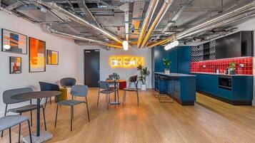 A modern interior with a neon sign reading 'DREAM,' wooden flooring, and a bar area with blue and red accents.