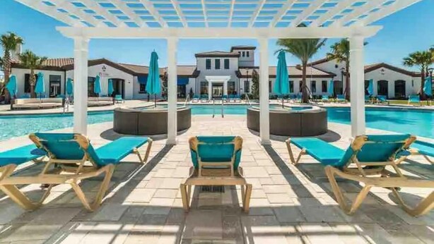 Ein Poolbereich mit Liegestühlen und einer Pergola.