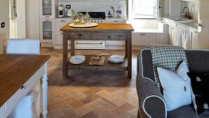 Una cocina acogedora con una mesa de madera, luces colgantes y un horno empotrado.