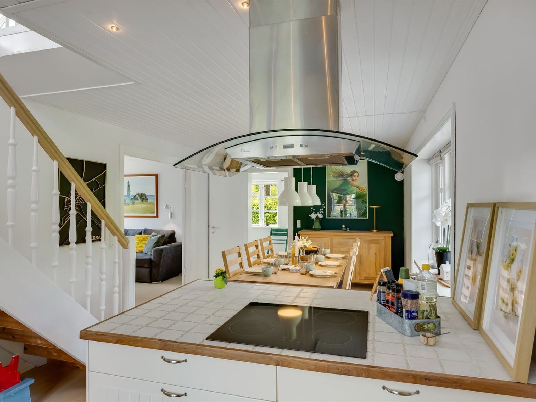 Une cuisine moderne dotée d’un îlot central, d’un coin repas et d’un escalier.