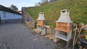 Deux fours en briques installés à l’extérieur, un chemin de gravier et un bâtiment doté de fenêtres.