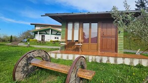 Una cabaña rústica con puerta de madera, un banco y una mesa afuera.