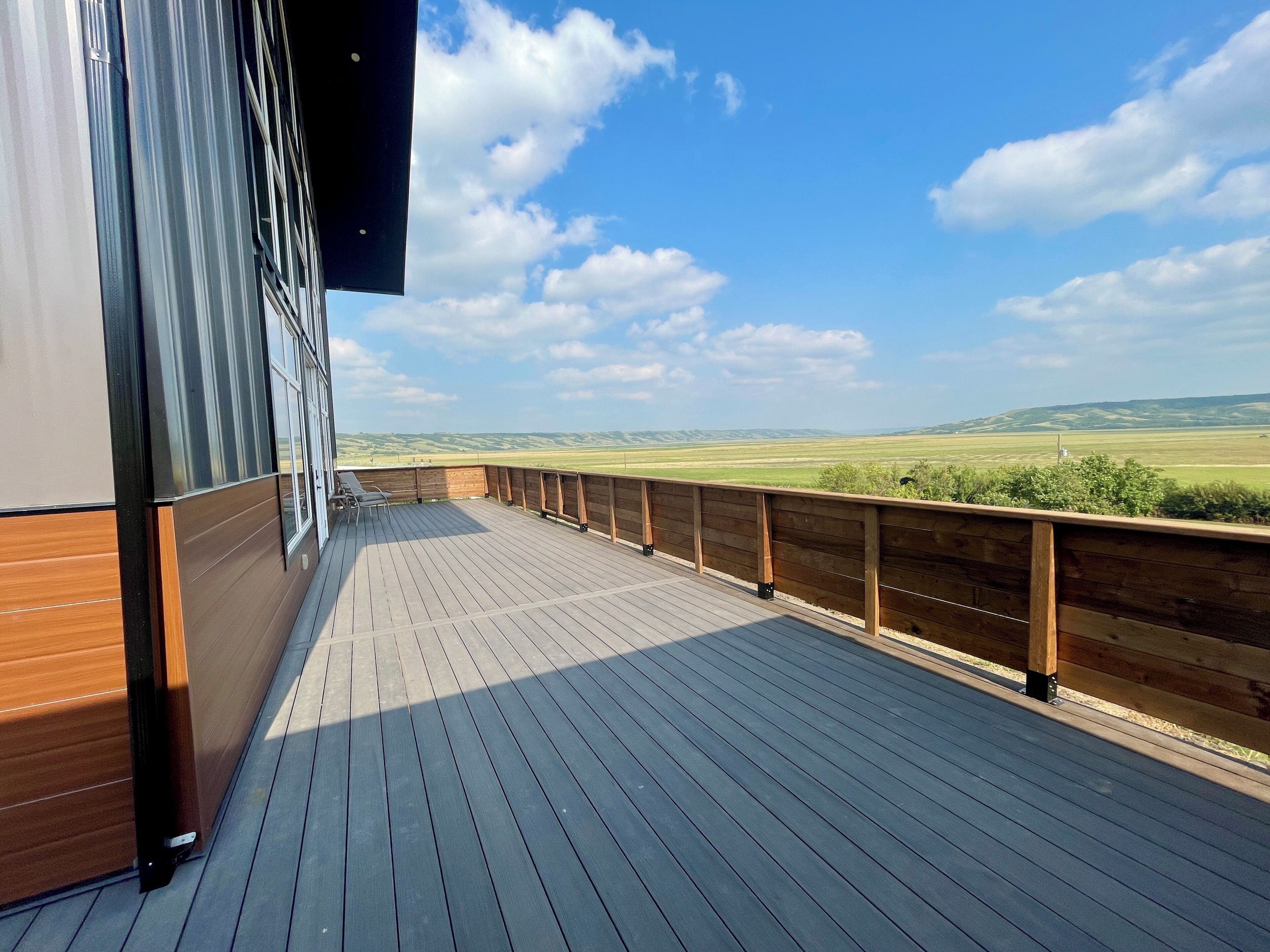 A wooden deck with a view of a green landscape.