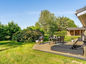 A deck with outdoor furniture, a grill, and a covered area with storage. - "Stefana" -  from the sea by Interhome (Hals)