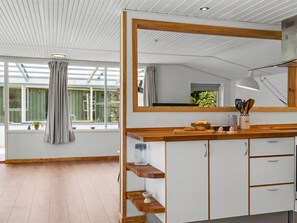 Eine moderne Küche mit einem großen Spiegel, Holzböden und Blick ins Freie.