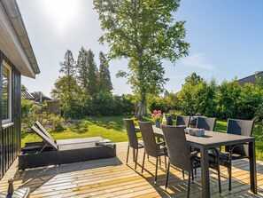 A deck with outdoor furniture, a table, and chairs. - "Stefana" -  from the sea by Interhome (Hals)