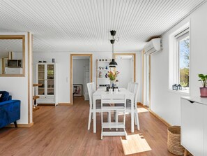Ein modernes Interieur mit Essbereich, heller Möbel und Blick durch ein Fenster.