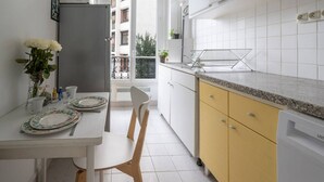 Keittiössä on valkoiset kaapit, keltainen työtaso ja näkymä parvekkeelle.