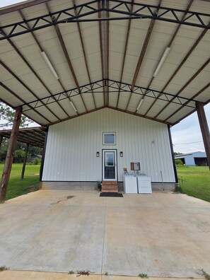 A single-story building with a metal roof and a door with a small window above it.