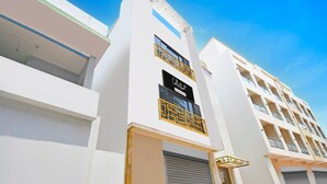 A modern building with a prominent 'Collection' sign, multiple balconies, and a clean architectural design.