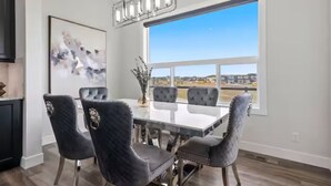 A dining area with a large window, a chandelier, and a painting on the wall. - Cozy and Inviting home, whole house to your self to stay with 2 free parkings. (Calgary)