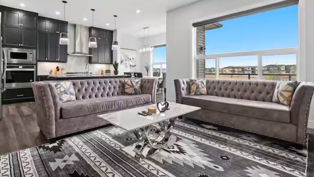 A modern living room with a gray sofa, a coffee table, and a patterned rug. - Cozy and Inviting home, whole house to your self to stay with 2 free parkings. (Calgary)