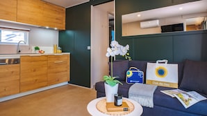A modern kitchen with wooden cabinets, a built-in oven, and a window above the sink. - Milano Marittima Boutique Resort (Cervia)