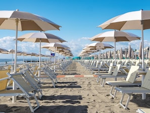 A beach with rows of sun loungers and umbrellas. - Milano Marittima Boutique Resort (Cervia)