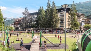 A playground with swings and slides, surrounded by trees and buildings. - Richardette by Interhome (Sauze d'Oulx)