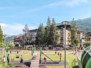 A playground with swings and slides, surrounded by trees and buildings. - Richardette by Interhome (Sauze d'Oulx)