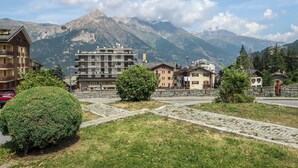 A mountainous town with buildings, a cobblestone path, and a prominent mountain in the background. - Richardette by Interhome (Sauze d'Oulx)
