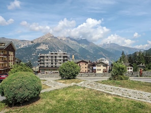 A mountainous town with buildings, a cobblestone path, and a prominent mountain in the background. - Richardette by Interhome (Sauze d'Oulx)