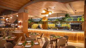 A restaurant with wooden ceiling, bar area, and dining tables with chairs. - Elegant Midtown Studio Plus at The Quin – Central Park & Broadway Nearby (New York City)