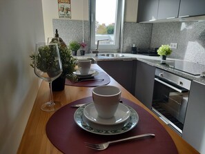 Eine Küche mit Essbereich, einem Spülbecken, einem Bosch-Ofen und einem Fenster mit Aussicht.
