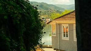 Una casa con techo de tejas, una ventana con vista a un lago y un balcón.