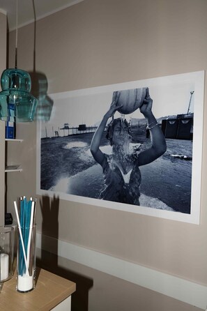 A photograph of a person holding a bucket over their head, with a pier and boats in the background. - 50 Suite B&B (Naples)