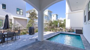 A swimming pool with a patio area, outdoor furniture, and a covered seating area. - Luxury Home on 30A~ 5 min walk to beach~ 4 bikes! (santa rosa beach)