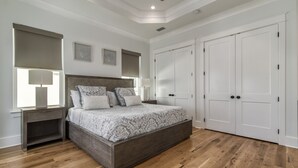 A bedroom with a bed, nightstands, a ceiling fan, and a wardrobe. - Luxury Home on 30A~ 5 min walk to beach~ 4 bikes! (santa rosa beach)