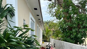A concrete planter with various potted plants, a concrete wall, and a building with windows in the background. - Cozy 1-bedroom apartment in terrific Nassau with AC (Nassau)
