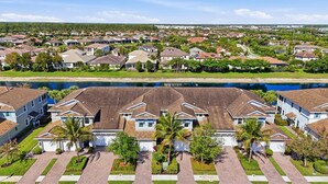 A residential area with houses, a lake, and a clear sky. - Lakefront Luxury + Stunning Naples Sunsets (Naples)