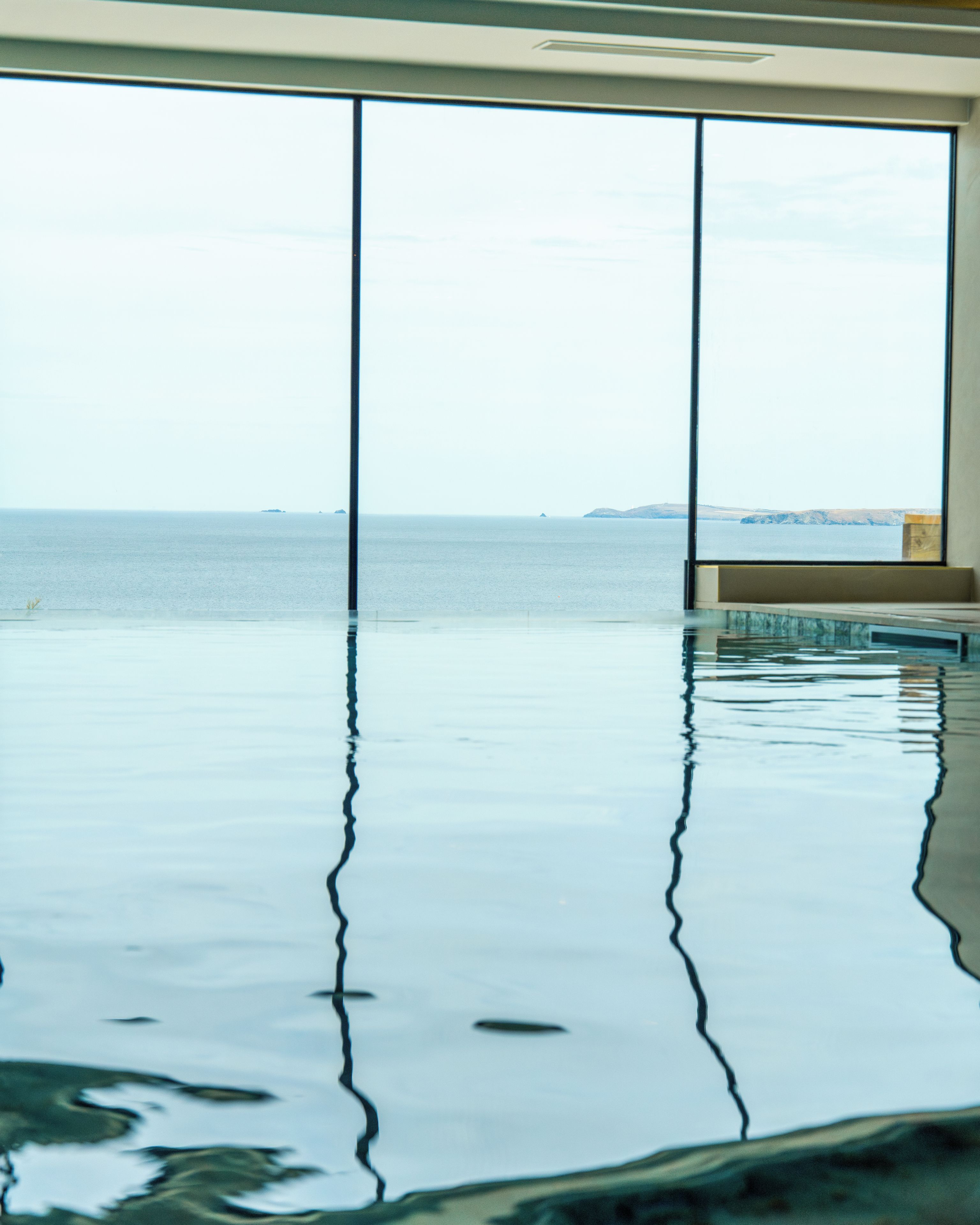 Ein unendlicher Pool mit freiem Blick auf das Meer und das entfernte Land.