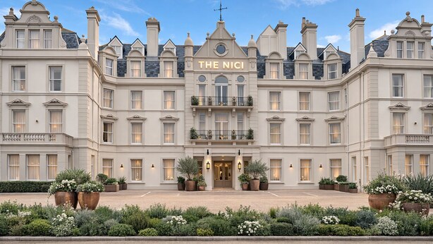 Façana imponent d'un hotel amb un senyal prominent que diu 'THE NICI'.