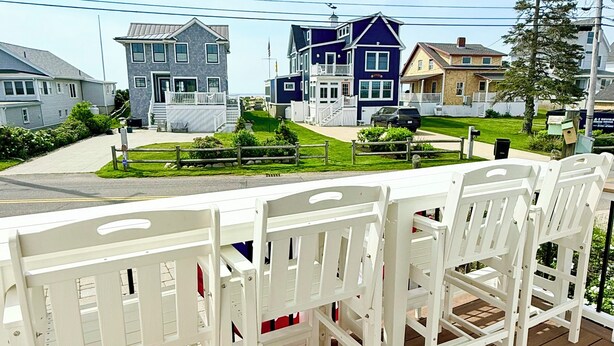 A wooden deck with white chairs, a view of houses, and a clear sky. - The Tinker Bell at Moody Beach- Turtle Unit 2 BR’s with partial ocean views (Wells)