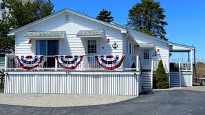 A white building with a porch, a garage, and a small tree in front. - The Tinker Bell at Moody Beach- Turtle Unit 2 BR’s with partial ocean views (Wells)